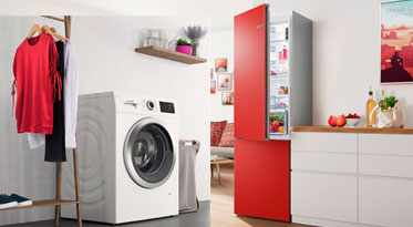 Lavadora y frigorífico Combi con puertas rojas en cocina blanca.